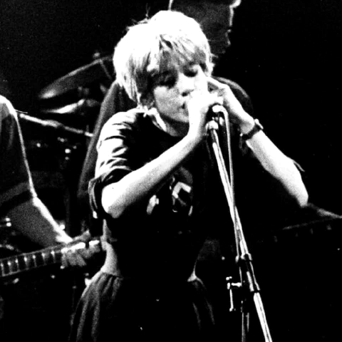 Miki Berenyi, chanteuse de Lush, au micro sur scène, photographie noir et blanc grenée prise depuis la fosse, vers 1990